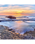 Ocean retreating gently across reef under soft light and wide sky