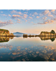 Ocean inlet surrounded by forested headlands in warm light