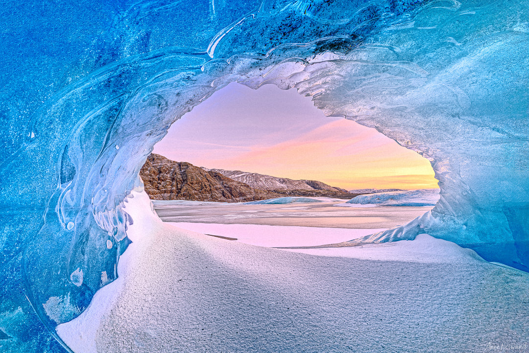 Ice cave framing Arctic valley in twilight