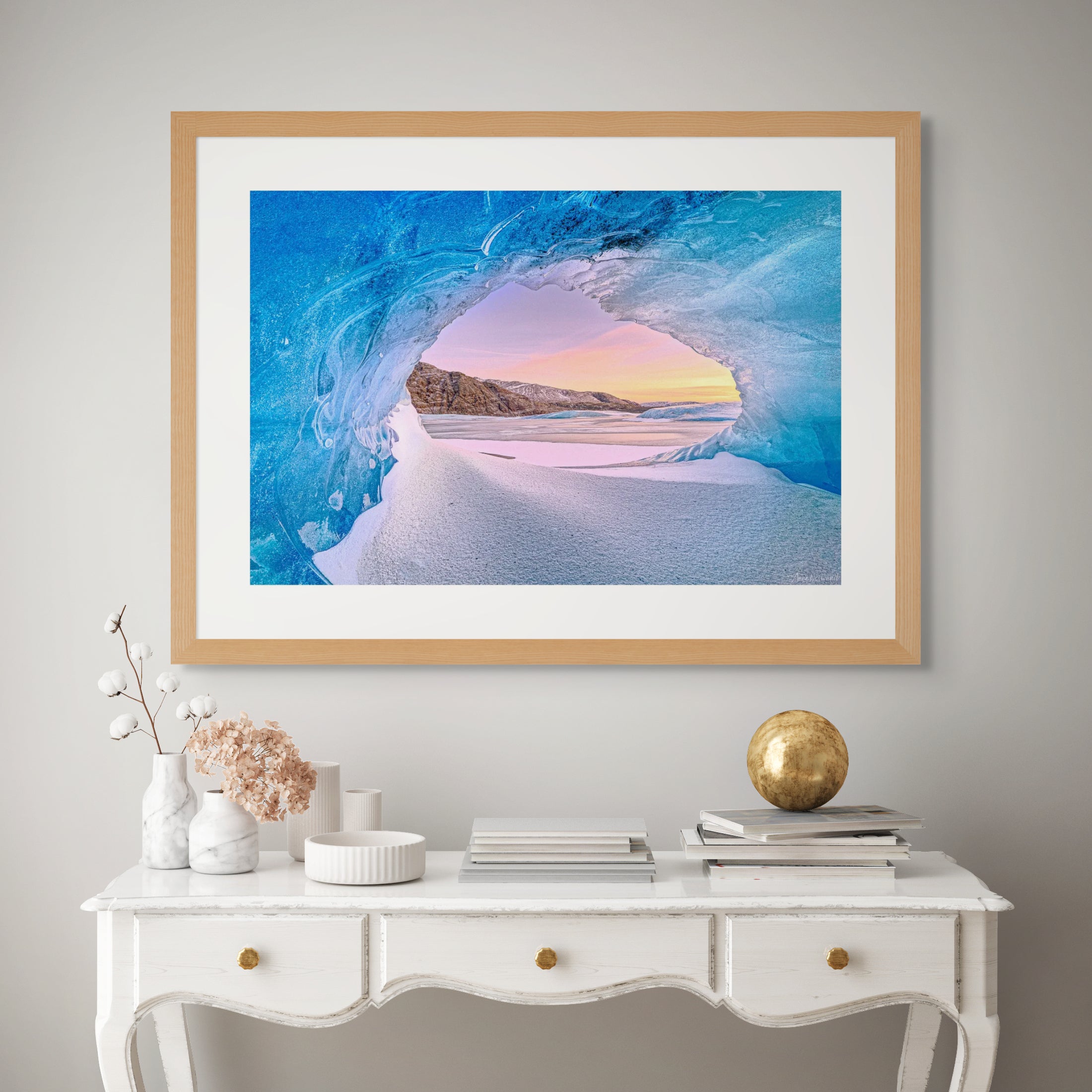 Tranquil blue ice cave interior with a warm sunset sky visible through the opening onto a frozen lake in Iceland Framed Wooden