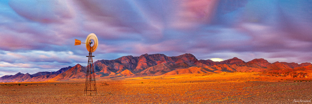 Old windmill and red earth under dramatic sky in Flinders Ranges, South Australia