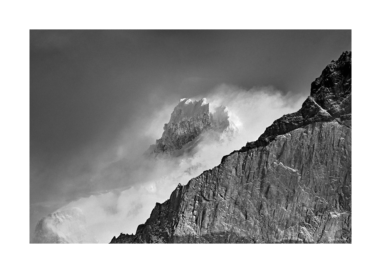 snow and cloud swirling around mountain peak
