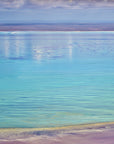 Aerial view of shimmering turquoise water with soft cloud reflections