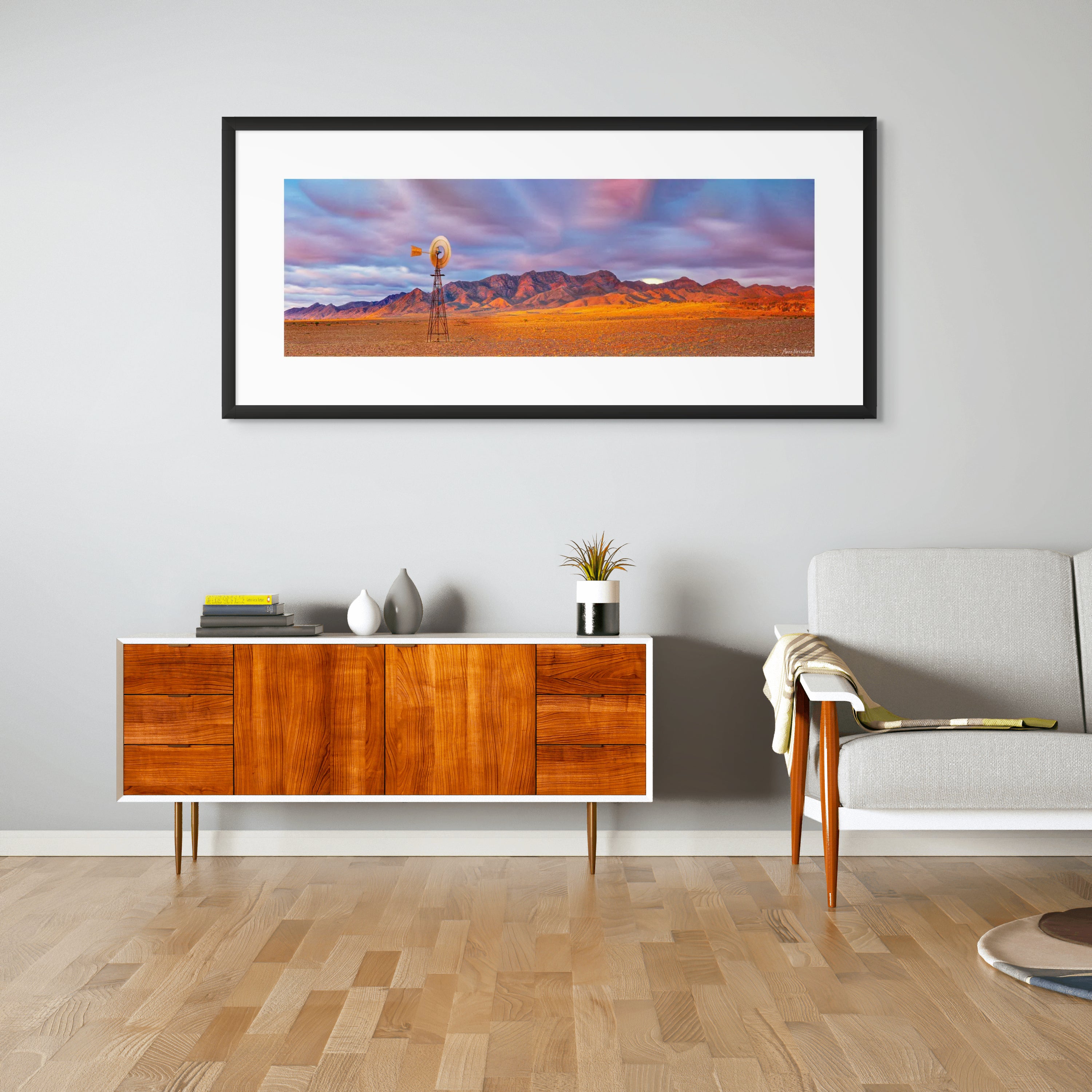 Outback landscape with stormy sky and weathered windmill in golden light